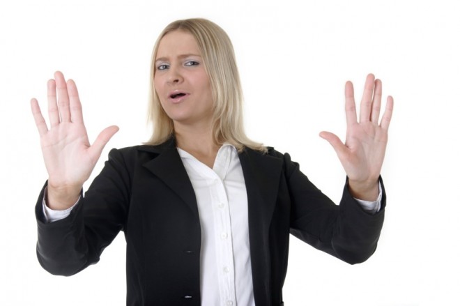 business woman holding up hands, "back up"